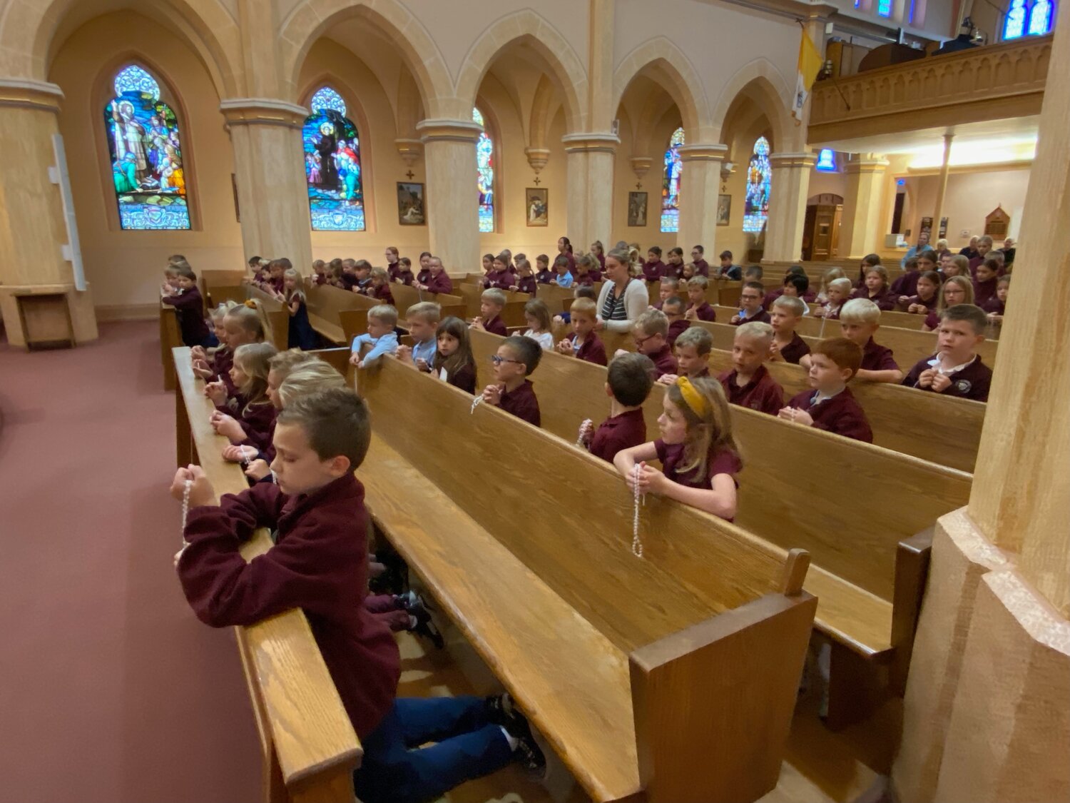 Students of St. George School in Hermann gather in church to pray the Rosary together.